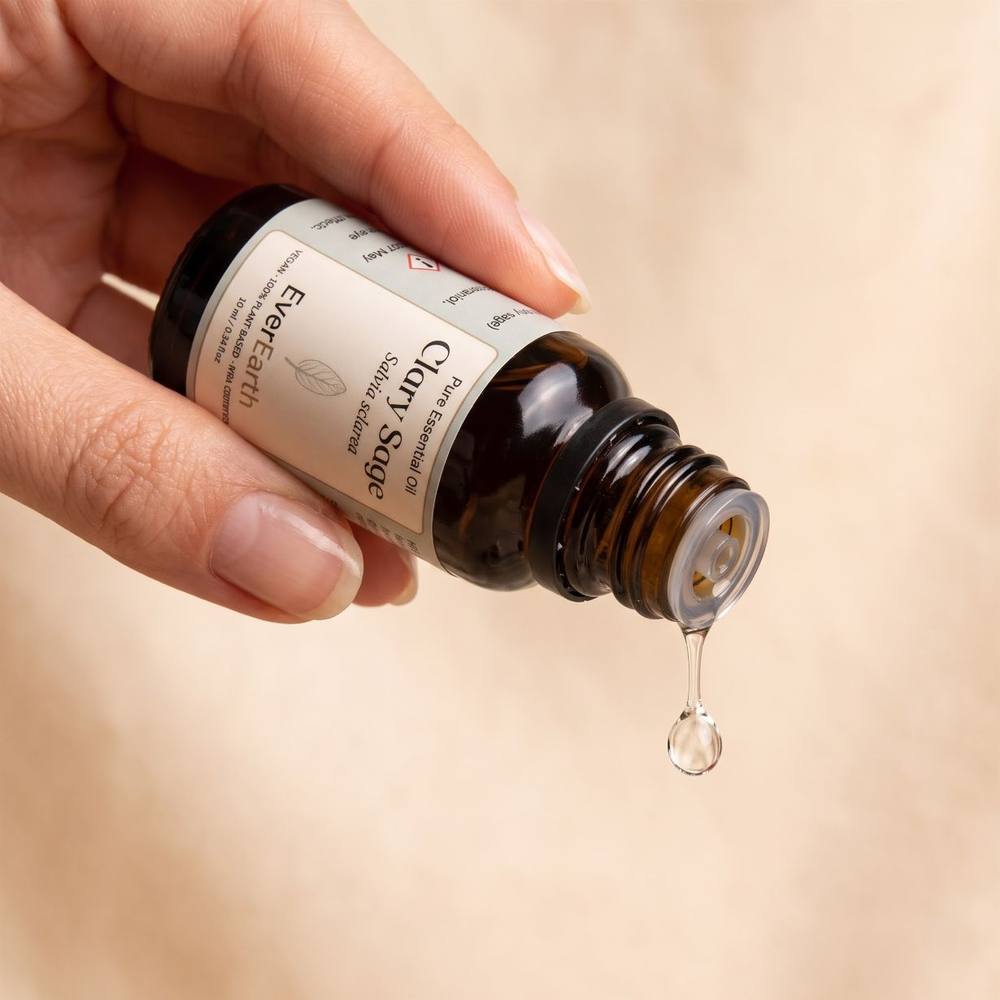 Hand dispensing a drop of EverEarth Clary Sage essential oil from the amber glass bottle
