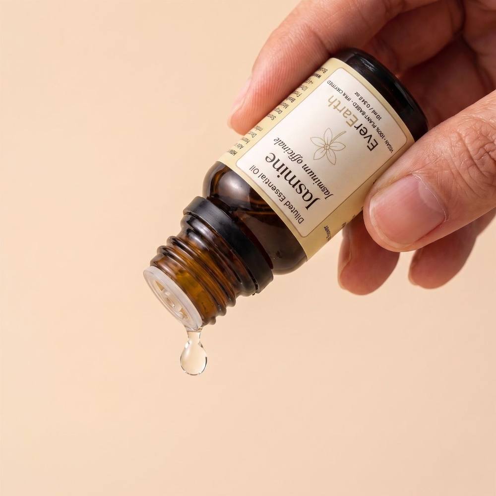 Hand tilting EverEarth Jasmine essential oil bottle to release a single drop