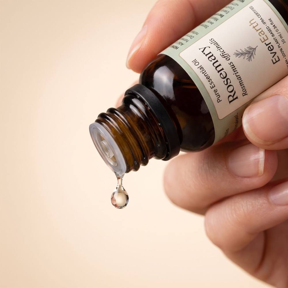 Hand tilting EverEarth Rosemary essential oil bottle to release a single drop